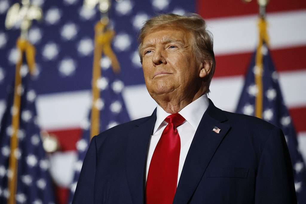 President Donald J. Trump standing in front of American flags